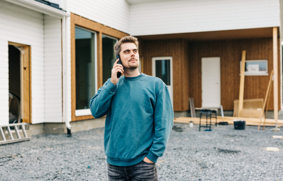 Mies puhumassa puhelimeen rakennustyömaalla