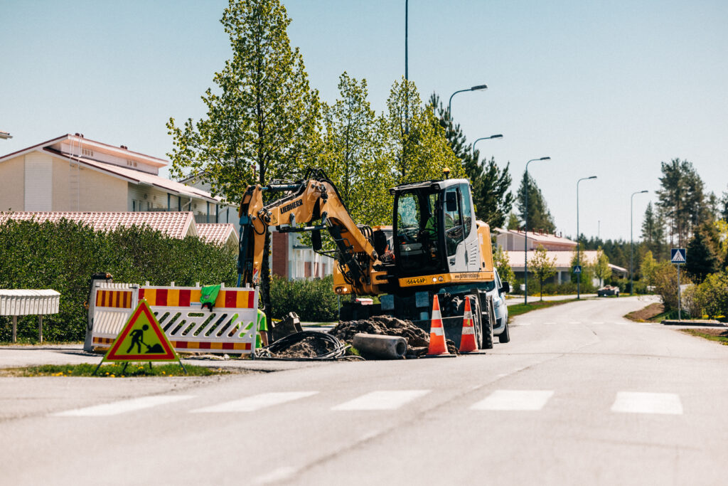 Kaivinkone kaivamassa kadulla